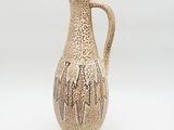 a small vase with a handle on a white surface