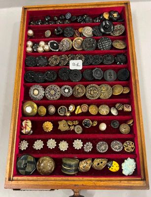 une vitrine remplie d'une multitude de boutons et de broches