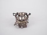 a silver plated crab with two legs and two legs on it