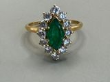 a close up of a green and white diamond ring on a table