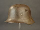 an old helmet on a stand on a gray background
