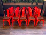 several red chairs are lined up in a row in front of a planter