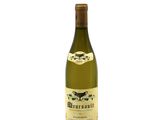 the bottle of white wine is sitting on a white surface