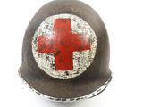 an old helmet with a red cross painted on the side of it