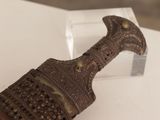 a small metal object on display on a white surface