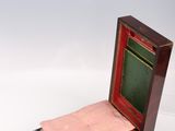 a small wooden box with a pink blanket inside of it