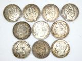 six different types of silver coins are arranged on a white surface