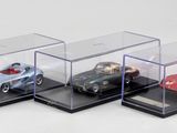 trois voitures miniatures dans une vitrine posée sur une surface blanche