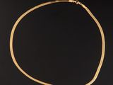 gros plan d'un collier en or sur fond noir