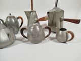 a group of silver teapots and coffee pots on a white surface
