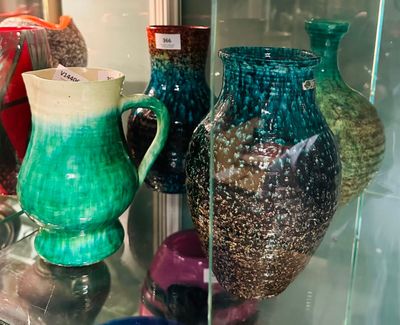 de nombreux vases de différentes couleurs exposés dans une vitrine