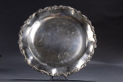 assiette en argent sur un support, sur fond gris avec un fond noir