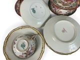 several different types of china plates and bowls on a white surface