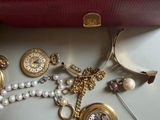 a red box with a bunch of jewelry inside of it