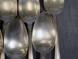 six spoons that are sitting on a black cloth