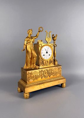 une horloge en or surmontée d'une statue