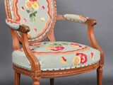 an old chair with a floral upholstered back and wooden legs