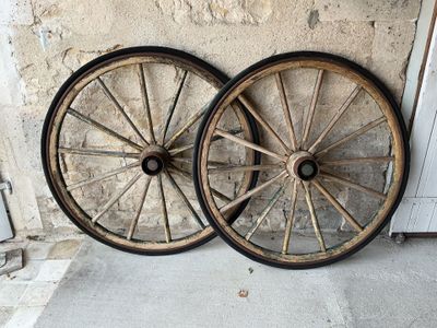 two old wooden wheels sitting next to each other