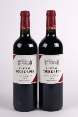 two bottles of red wine sitting next to each other on a white surface