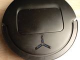 black robotic vacuum cleaner on a wooden table with a black background
