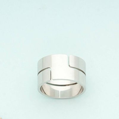 a silver ring with a cross on it on a blue surface