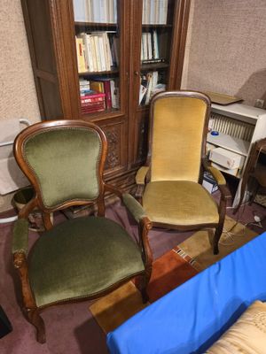 two chairs in the corner of a room next to a bookcase