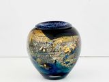 a blue and gold vase sitting on a white surface