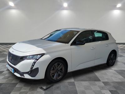une voiture blanche est garée dans une pièce au sol à carreaux