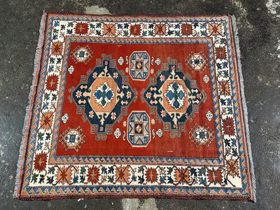 un tapis oriental orange et bleu posé sur un sol en béton