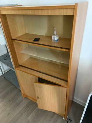 a wooden bookcase with two shelves and a laptop on the floor