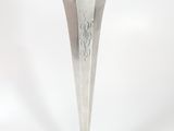 a silver vase that is sitting on a white surface