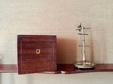 a wooden shelf with a clock and a box on top of it