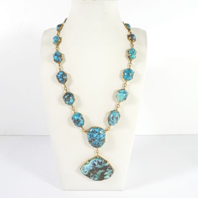 a necklace with a blue and green stone pendant on a mannequin