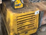 une machine jaune posée sur une palette dans un entrepôt