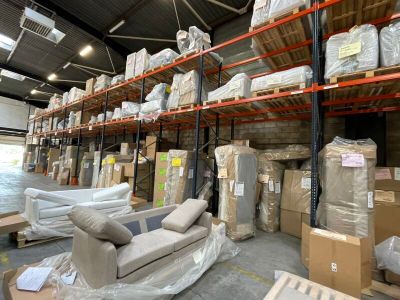 un grand entrepôt rempli de nombreuses cartons et de canapés