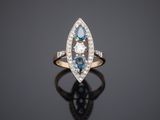 a blue and white diamond ring on a black surface