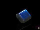 a close up of a blue stone on a black surface
