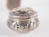 a silver box sitting on a white surface with a brown object in the background