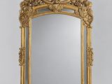a large gold mirror with a floral design on the frame