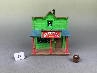 un petit bâtiment vert avec une enseigne sur la façade