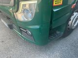 a green truck with a yellow sticker on the front of it