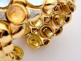 a close up of a gold ring with multi colored stones