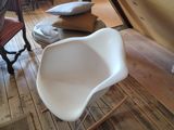 une chaise blanche posée sur un parquet dans un salon