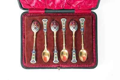 five spoons in a case with a red velvet lining