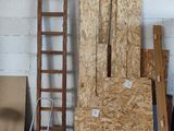 several pieces of plywood are stacked up in a room with a ladder