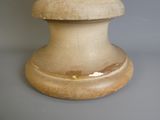 un vase blanc au pied marron posé sur une table