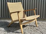 the chair is made of wood and has a woven seat