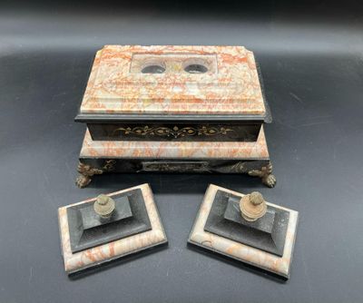 deux bougies anciennes en marbre et une boîte posées sur une surface noire