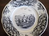 a black and white plate with a picture of a man on a boat