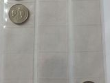 three coins in a clear plastic bag on a table